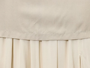 Détail de la couture plissée à la taille et des finitions de cette jupe midi beige