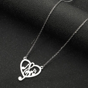 Close-up of a silver music note heart pendant necklace on a black textured background