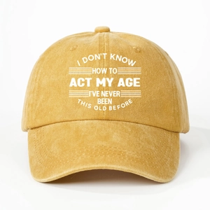 Detail of mustard yellow washed cotton baseball cap with white printed humorous quote text