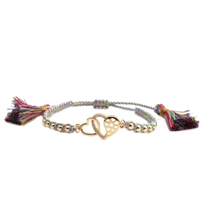 Detail of colorful woven bracelet featuring a gold double heart pendant with cubic zirconia