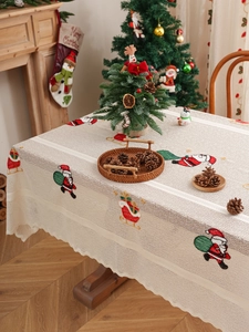 Detail of Christmas tablecloth featuring Santa Claus motif and scalloped lace edge