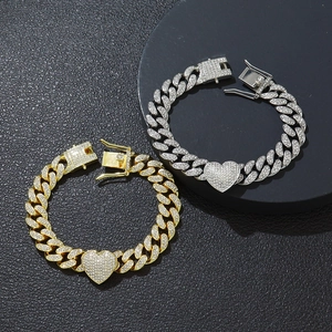 Bracciali a catena cubana con strass oro e argento e ciondolo a cuore su pelle