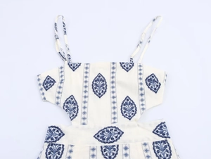 Detailed view of the blue floral embroidery and hollow-out waist on the off-white midi dress