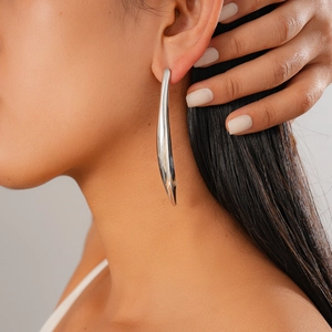 Gros plan d'une boucle d'oreille barre en argent minimaliste portée par un mannequin