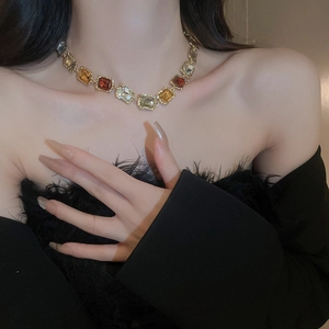 Close-up of vintage gold choker necklace with multicolored square rhinestones on model
