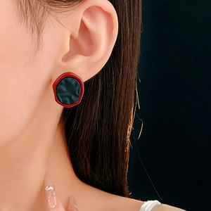 Gros plan de boucles d'oreilles géométriques rouge et noir au style vintage élégant