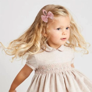 Fillette portant une barrette nœud en dentelle rose faite de tissu doux et métal