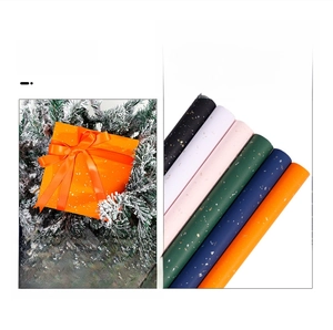 Multiple rolls of premium gift wrapping paper with gold dusting and vibrant colors