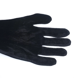 Détail de gants de soirée en velours noir montrant la texture douce du tissu de qualité