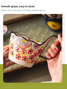 Detail of hand-painted floral ceramic mug with wavy rim and thick heat insulation grip