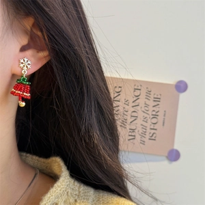 Detailed close-up of handmade beaded Christmas tree earrings with red bow and snowflake stud