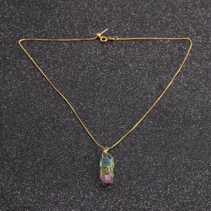 Detailed macro view of rainbow crystal pillar pendant wrapped in gold wire