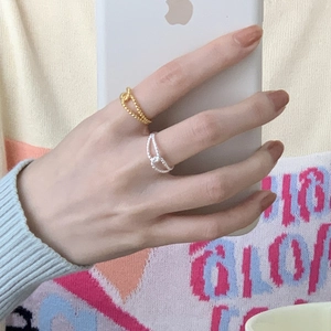 Detail of twisted knot minimalist rings in gold and silver finish on model's hand