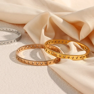 Macro view of hollow star cut-outs on gold, silver, and rose gold stainless steel bangles