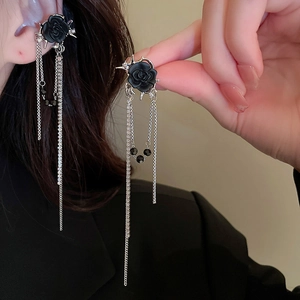 Detail view of black rose earrings with elegant long silver fringe tassels on model