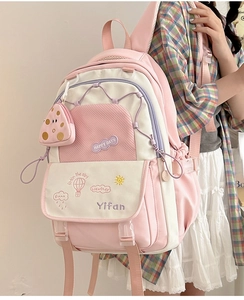 Pink and cream lightweight nylon backpack with matching coin purse shown on a model