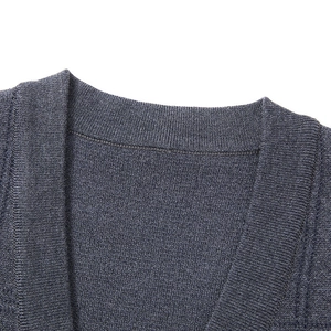 Detailed macro view of V-neck stitching and ribbed texture on dark blue knit vest