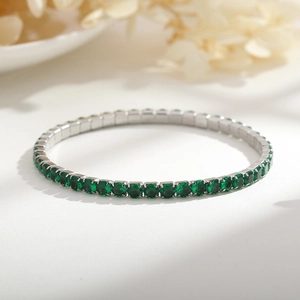 Dettaglio del bracciale tennis argento 4mm con pietre verde smeraldo su sfondo chiaro
