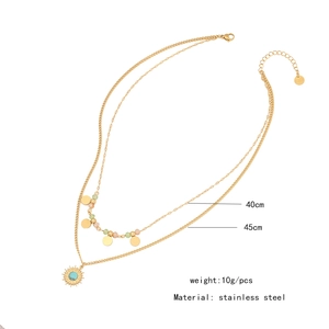 Close-up of double-layered stainless steel necklace with sun pendant and turquoise stone