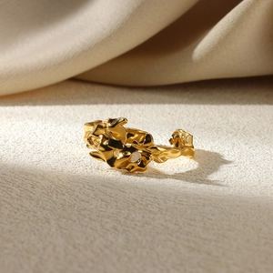 Macro detail of golden irregular lava texture on an adjustable open geometric ring