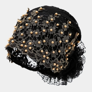 Détail de la dentelle florale noire ornée de broderies de perles dorées champagne