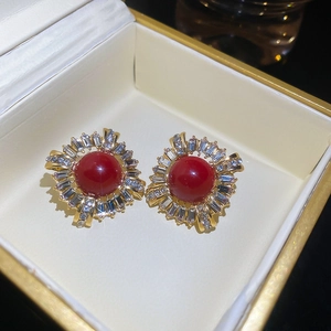 Detailed macro view of vintage red stone stud earrings with sunburst zircon halo