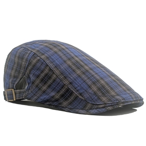 Détail de la casquette plate à carreaux bleus et gris avec boucle réglable en laiton