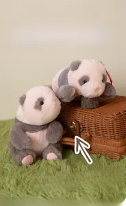 Close-up of pink and grey plush panda cubs sitting in a brown woven basket on green rug