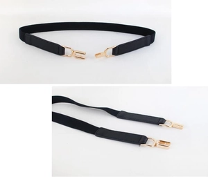 Detail of a slim black elastic waist belt featuring a polished gold interlocking buckle