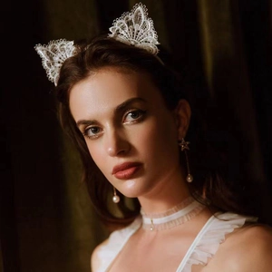 Close-up of white lace cat ears headband with pearl earrings and matching choker set