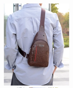 Detail shot of brown PU leather men's chest bag with metal logo and earphone hole