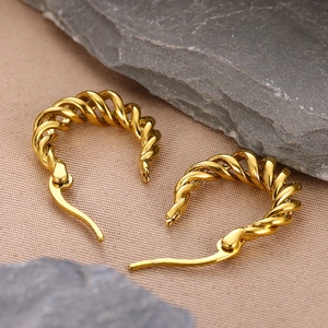 Minimalist twisted gold geometric hoop earrings displayed on a textured stone surface