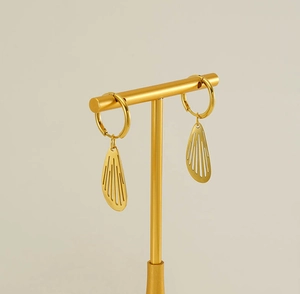 Detail of gold-plated stainless steel hoop earrings with hollow wing-shaped pendants