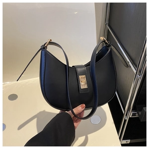 Détail du sac demi-lune noir avec boucle métallique dorée et finition en cuir texturé