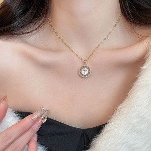 Gros plan du collier plaqué or 18 carats avec zircons et pendentif croix en nacre blanche