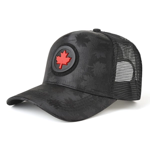 Detail of black trucker hat featuring red maple leaf emblem and breathable mesh back