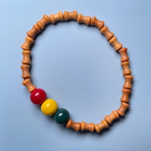 Detailed top view of sandalwood bamboo-shaped beads and colorful lacquer beads on a bracelet