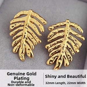 Detailed macro view of gold-plated leaf earrings with hammered texture and true gold finish