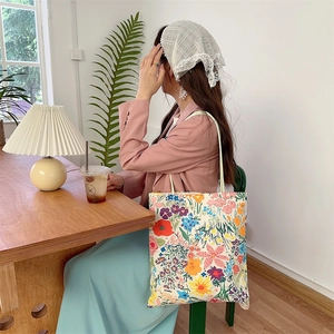 Détail d'un sac cabas en toile avec imprimé floral coloré et texture de toile robuste