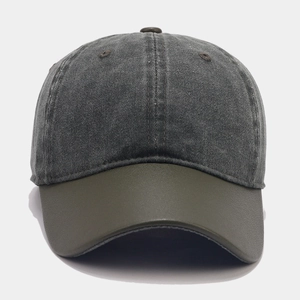 Detail of contrast stitch baseball cap featuring dark denim crown and olive green brim
