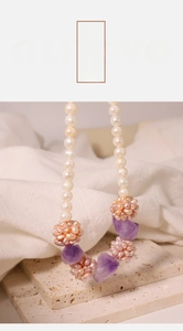 Detailed close-up of freshwater pearl necklace with amethyst stones and pink bead ball