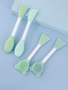 Close-up of double-headed silicone face brushes and mask applicators for skin care