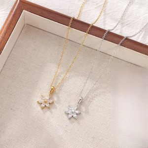 Elegant gold and silver flower necklaces with marquise zircon petals on linen display
