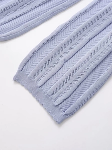 Detail of lavender knit fabric featuring hollow-out pattern and scalloped wave edges