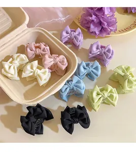 Detail view of colorful satin ribbon bow hair claws in a charming creative gift packaging