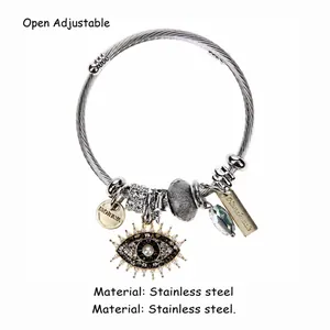 Detail of evil eye charm with micro-pave crystals on stainless steel cable bracelet