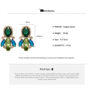 Detail view of luxury geometric tassel earrings with colorful zircons and copper setting