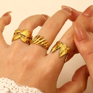 Minimalist gold leaf rings including gingko and feather designs on a female hand