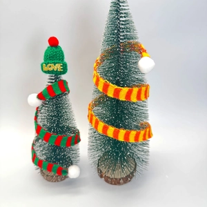 Mini Christmas bottle brush trees with knit scarves and hats on wooden bases