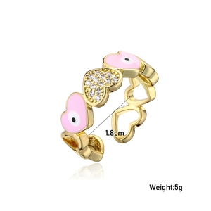 Detail view of gold adjustable heart ring with pink enamel evil eye and pavé zircons